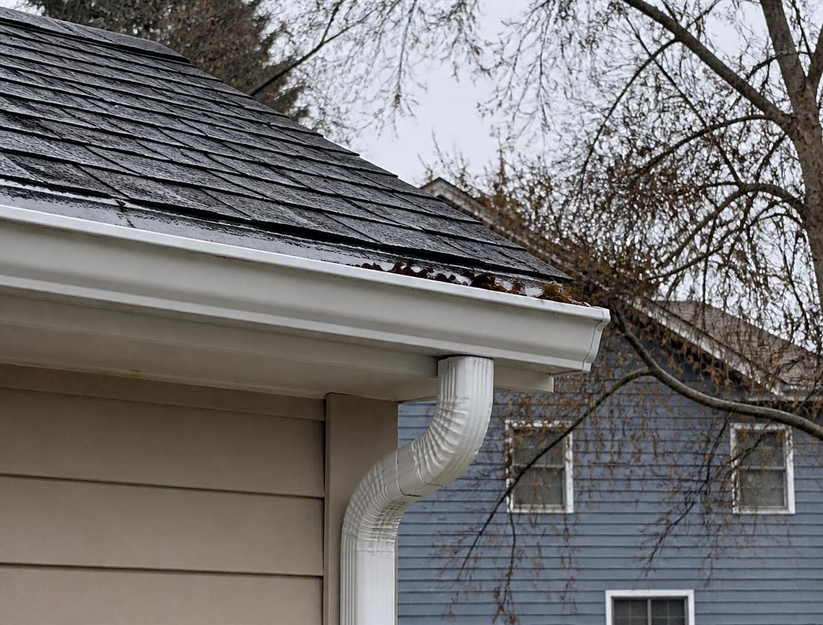 New metal gutter and downspout on a home roofline